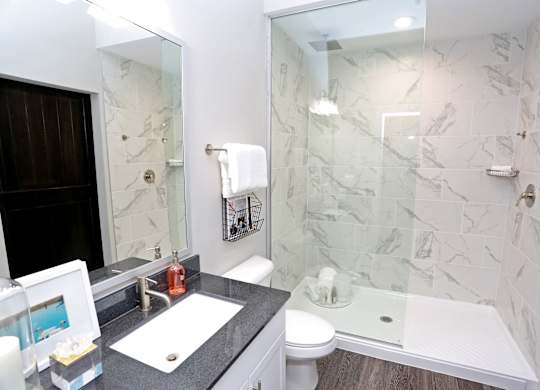 a bathroom with a shower and a sink and a mirror at Century Baxter Avenue, Louisville, KY 40204