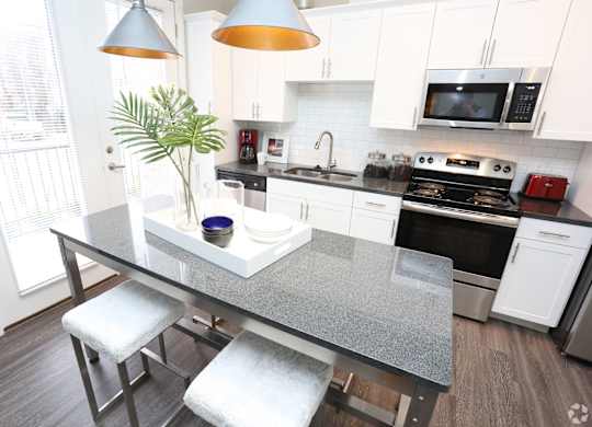 a kitchen with white cabinets and a gray counter top at Century Baxter Avenue, Louisville, 40204