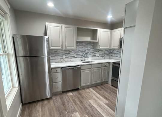 a kitchen with white cabinets and stainless steel appliances at Briarcliff at Quechee Apartments, Quechee, 05059