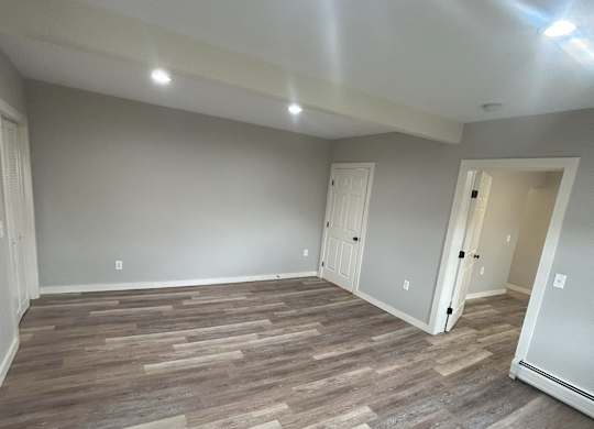 a living room with wood flooring and gray walls at Briarcliff at Quechee Apartments, Quechee