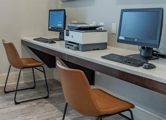 a computer desk with two monitors and two chairs at Century HomePlace, Prattville, AL 36066