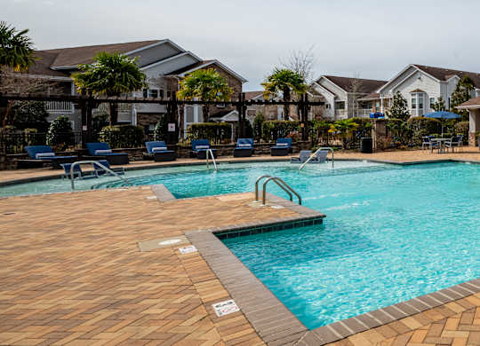 our apartments have a large swimming pool with chairs at Century HomePlace, Prattville, AL