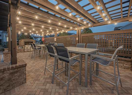 a patio with tables and chairs under a pergola at Century HomePlace, Prattville, AL