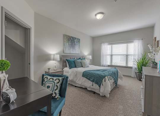 a bedroom with a bed and a desk and a window at Century HomePlace, Prattville, AL