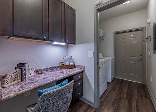 a kitchen with a counter top and a door to a laundry room at Century HomePlace, Prattville