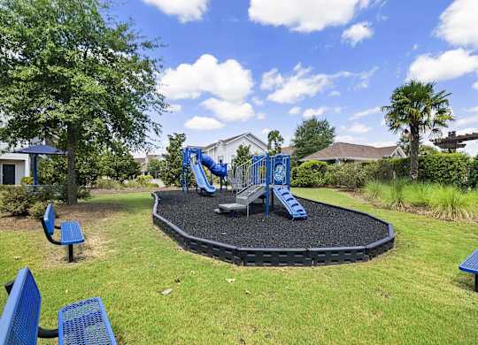 a playground with blue chairs and a black trampoline at Century HomePlace, Prattville