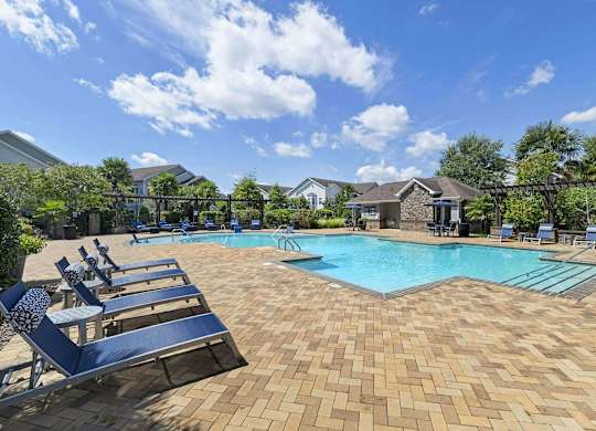 a resort style pool with blue lounge chairs around it at Century HomePlace, Prattville, AL