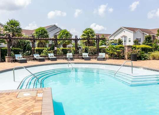 a swimming pool with chairs around it and a house in the background at Century HomePlace, Alabama, 36066