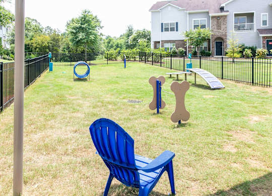 a park with a playground and a chair in the grass at Century HomePlace, Prattville, AL 36066