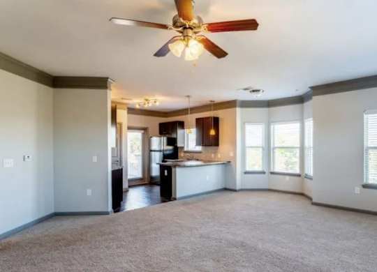 an empty living room with a ceiling fan and a kitchen at Century HomePlace, Prattville Alabama
