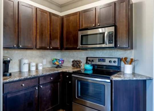 a kitchen with stainless steel appliances and wooden cabinets at Century HomePlace, Alabama, 36066