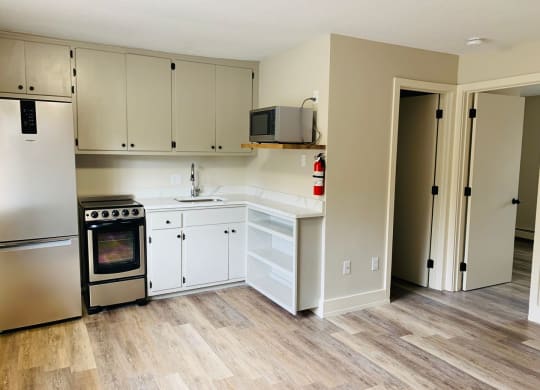 a kitchen with white cabinets and a wood floor at Briarcliff at Quechee, Quechee