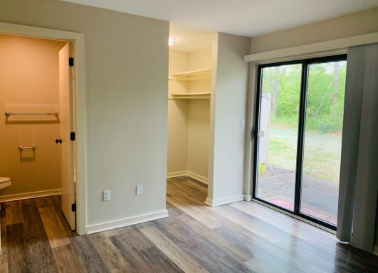 a living room with a sliding glass door and a closet  at Briarcliff at Quechee Apartments, Vermont