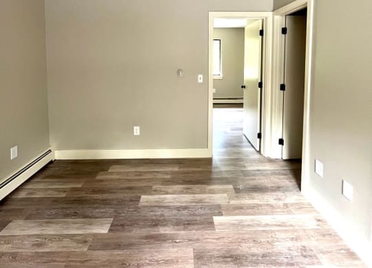 a renovated living room with wood floors and a hallway to a bedroom at Briarcliff at Quechee, Quechee, VT
