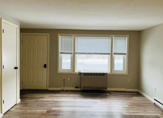an empty living room with a large window and a door at Briarcliff at Quechee, Vermont, 05059