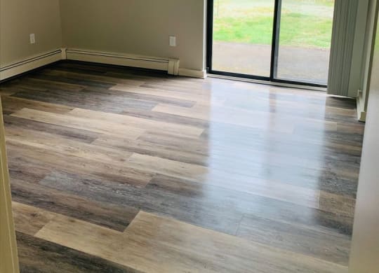 a living room with wood floors and a sliding glass door at Briarcliff at Quechee, Quechee Vermont