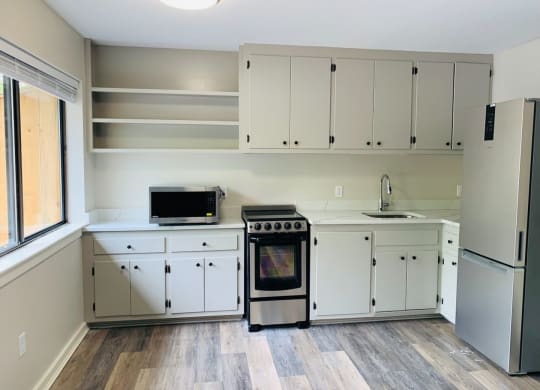 a kitchen with white cabinets and a stove and a refrigerator at Briarcliff at Quechee, Quechee Vermont