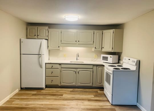 a kitchen with white appliances and white cabinets at Briarcliff at Quechee, Quechee, VT 05059