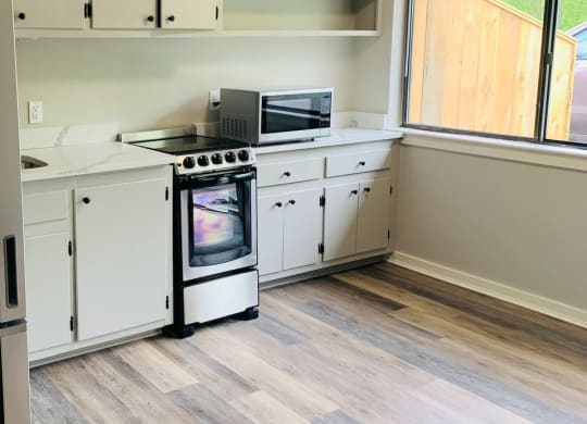 a kitchen with white cabinets and a stove and a window at Briarcliff at Quechee, Quechee, VT 05059