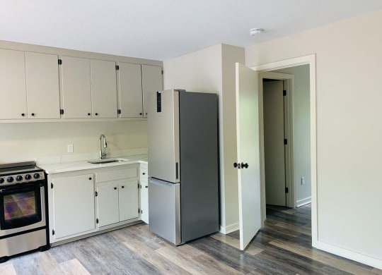 a kitchen with white cabinets and a stainless steel refrigerator at Briarcliff at Quechee, Vermont