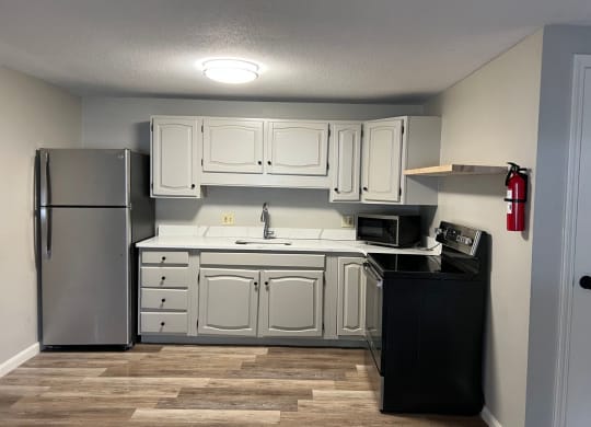 a kitchen with white cabinets and a stainless steel refrigerator at Briarcliff at Quechee, Vermont