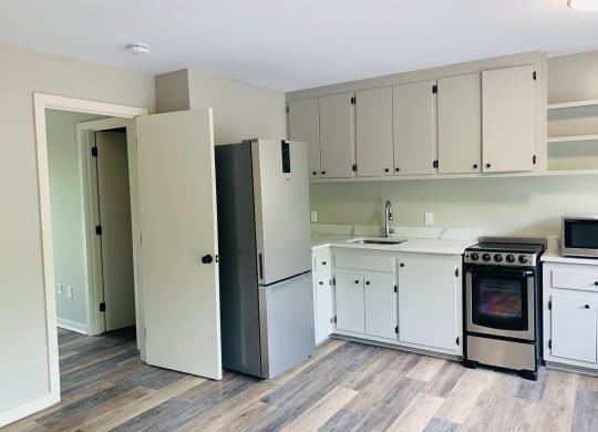 a kitchen with white cabinets and a stove and a refrigerator at Briarcliff at Quechee, Vermont