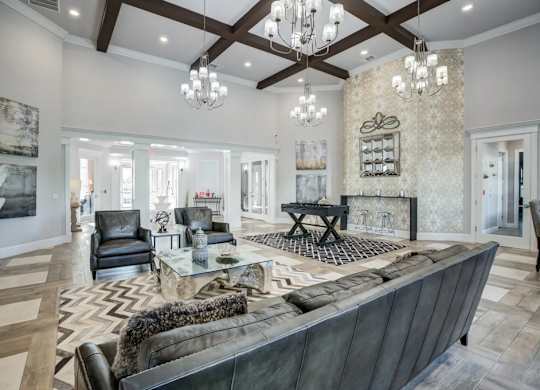 A large, modern living room with a dark leather couch and a fireplace.at Century Ariva, Lakeland, Florida