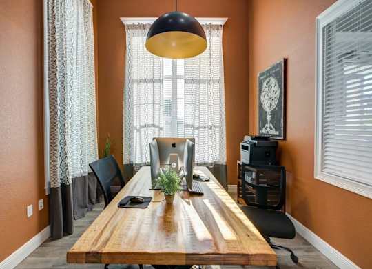 A room with a wooden table and a black lamp.at Century Ariva, Lakeland Florida