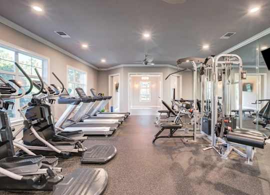 A well-lit gym with treadmills, elliptical machines, and other exercise equipment.at Century Ariva, Lakeland, 33812