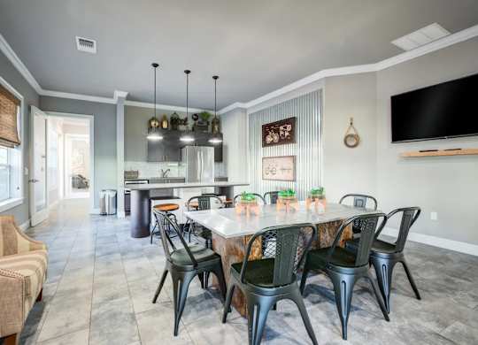 A dining room with a table set for six and a television mounted on the wall.at Century Ariva, Florida