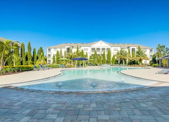 A large white building with a pool in front.at Century Ariva, Lakeland, FL 33812