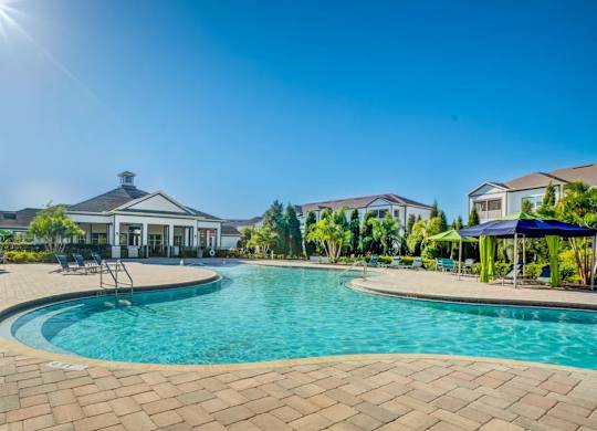 A large swimming pool surrounded by a brick patio and a house in the background.at Century Ariva, Lakeland, Florida