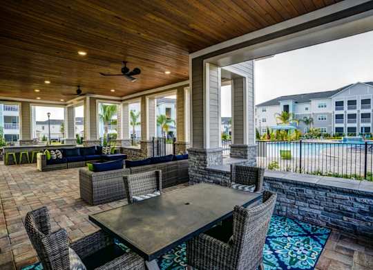 A patio with a table and chairs overlooking a pool.at Century Ariva, Lakeland
