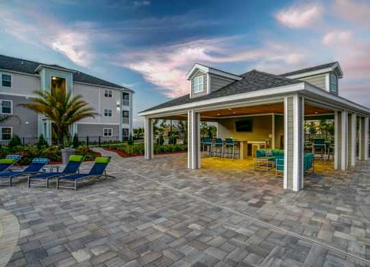 A patio area with a gazebo and chairs is surrounded by apartment buildings.at Century Ariva, Lakeland Florida