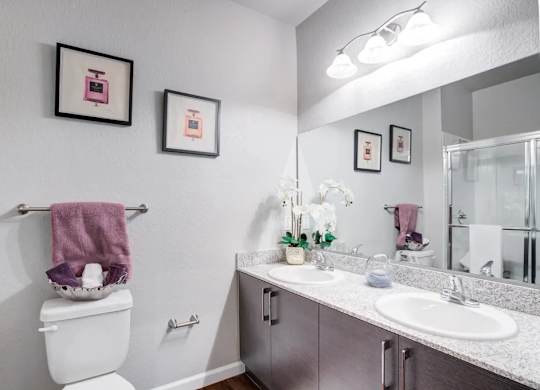 A bathroom with a toilet, sink, and towel rack.at Century Ariva, Lakeland, FL 33812