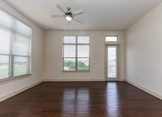 A room with a ceiling fan and wooden flooring.at Century Cedar Hill, Cedar Hill