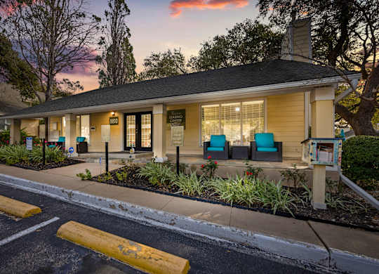 A building with a porch and a mailbox in front of it.