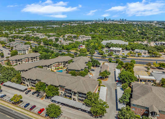 A bird's eye view of a residential area with apartment buildings and a pool.