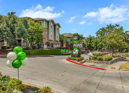 A street view of a residential area with a sign that reads