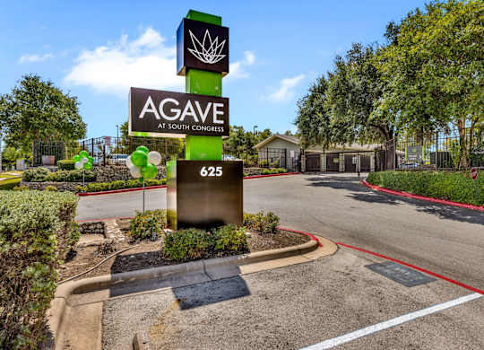 A sign for Agave at South Congress stands in front of a building.