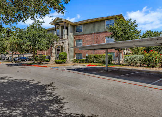A parking lot in front of a multi-story apartment building.
