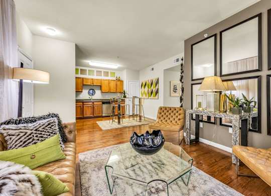 A living room with a brown leather couch and a glass coffee table.