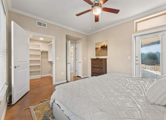 A bedroom with a large bed and a ceiling fan. at Bridge at Heritage Woods, Texas, 78753