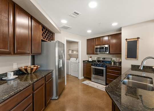 A kitchen with brown cabinets and a black counter top. at Bridge at Heritage Woods, Austin, Texas