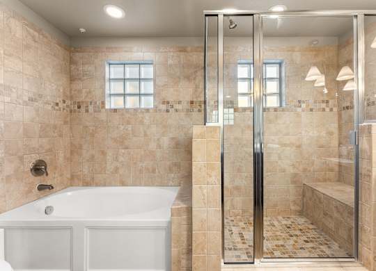 A bathroom with a white tub and a walk-in shower. at Bridge at Heritage Woods, Austin, 78753