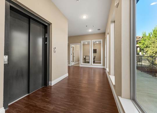 A hallway with a black door on the left and a glass door on the right. at Bridge at Heritage Woods, Austin, TX