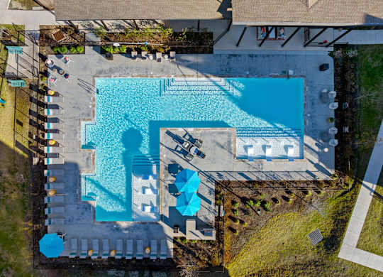 An aerial view of a swimming pool surrounded by a deck and a grassy area. at Bridge at Tech Crossing, Austin, 78753