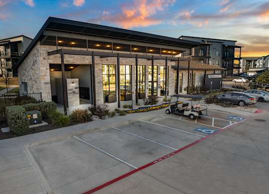 A parking lot in front of a building with a golf cart parked. at Bridge at Tech Crossing, Austin, TX, 78753
