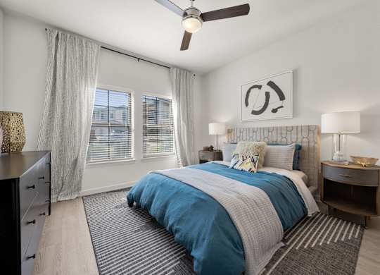 A bedroom with a bed, nightstands, and a ceiling fan. at Bridge at Tech Crossing, Austin