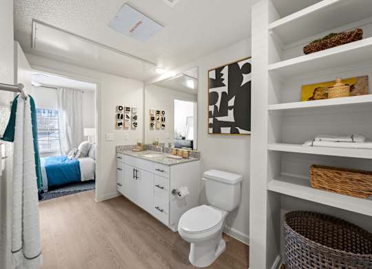 A white bathroom with a toilet, sink, and shelves. at Bridge at Tech Crossing, Texas, 78753